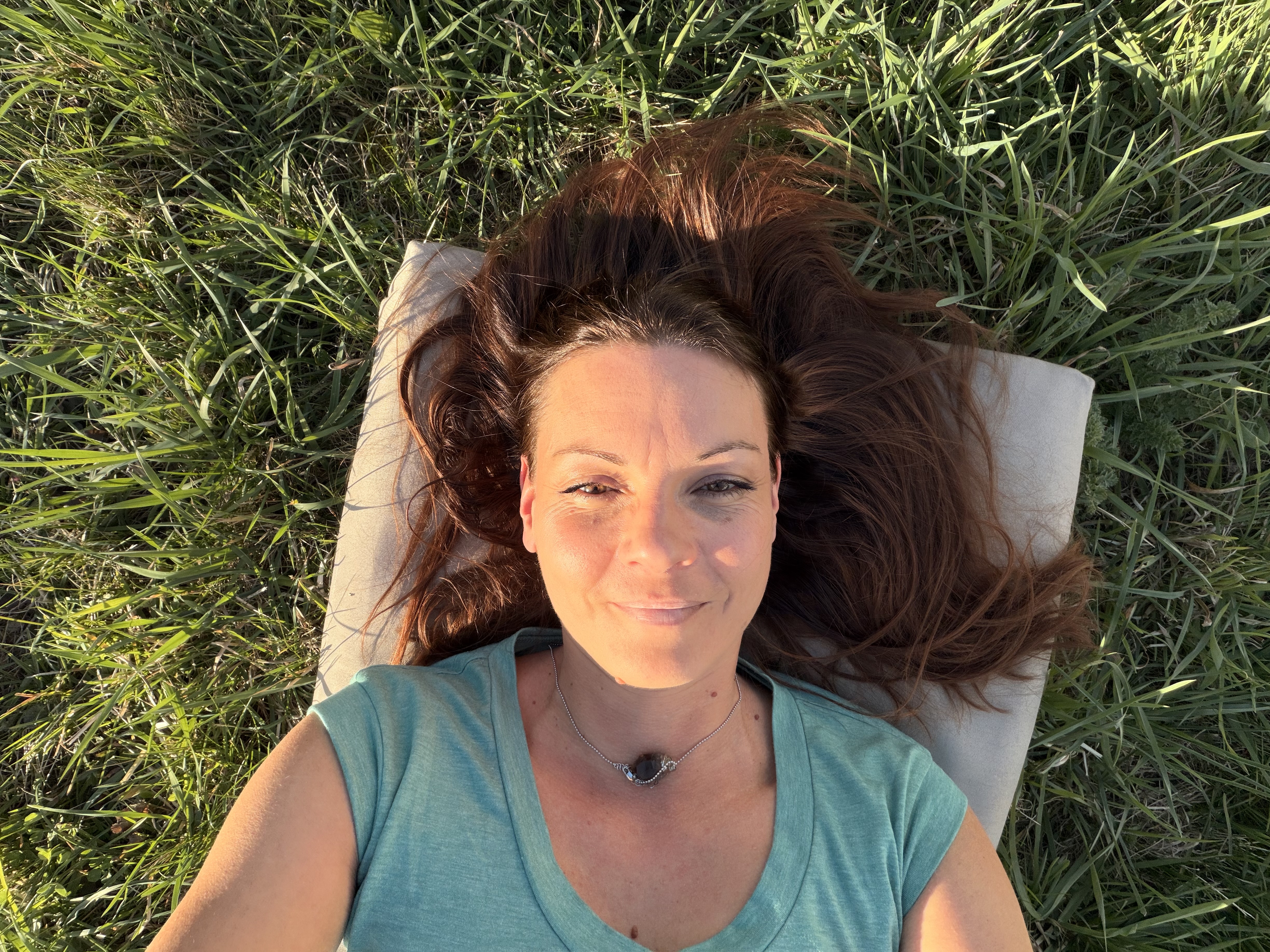 Melanie Gruber liegt im Gras, Augen ruhend